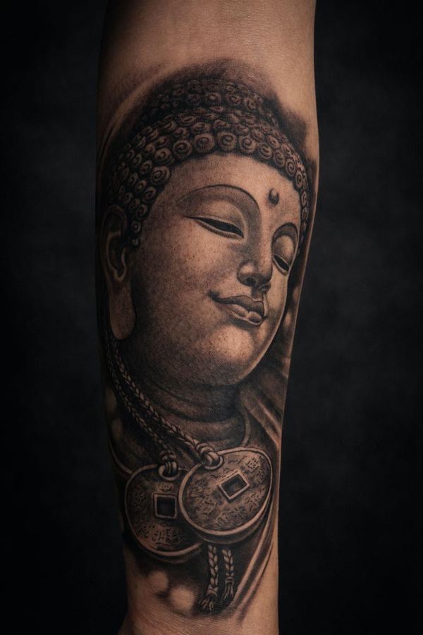 Tatuaje realista de Buda en antebrazo